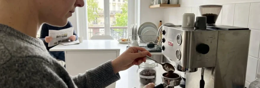 Une personne verse délicatement du café moulu dans le portafiltre d'une machine à expresso dans une cuisine contemporaine baignée de lumière naturelle